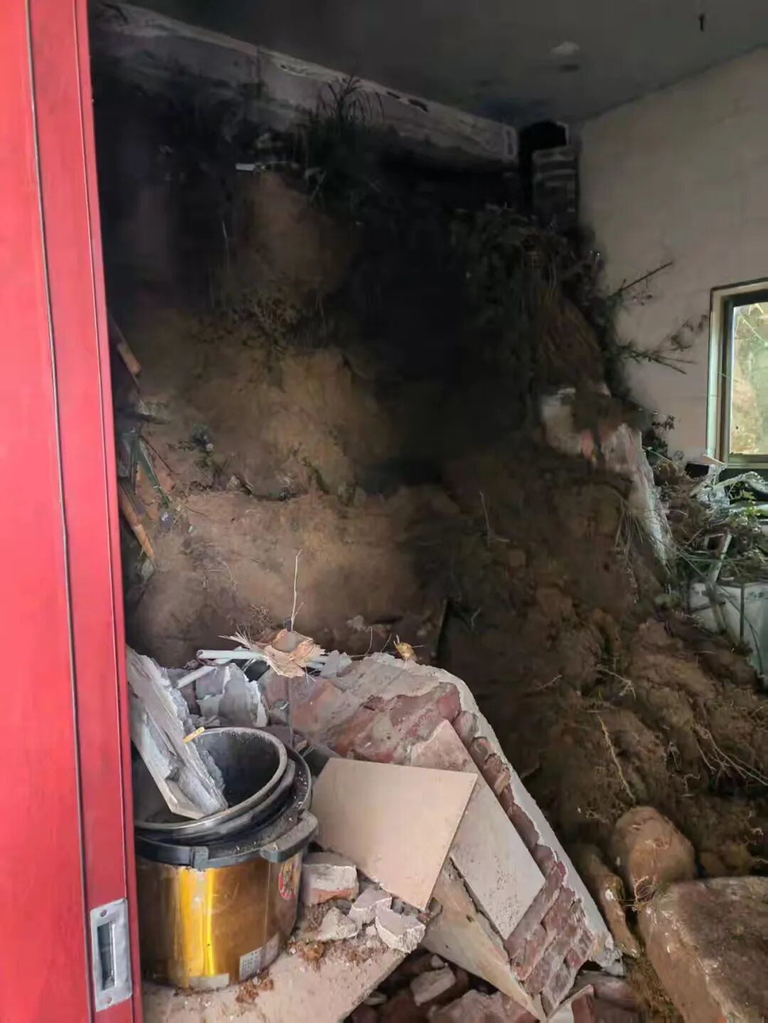 泥土冲入村民家中，屋内部分墙体及设施已被冲垮掩埋 / 受访者供图