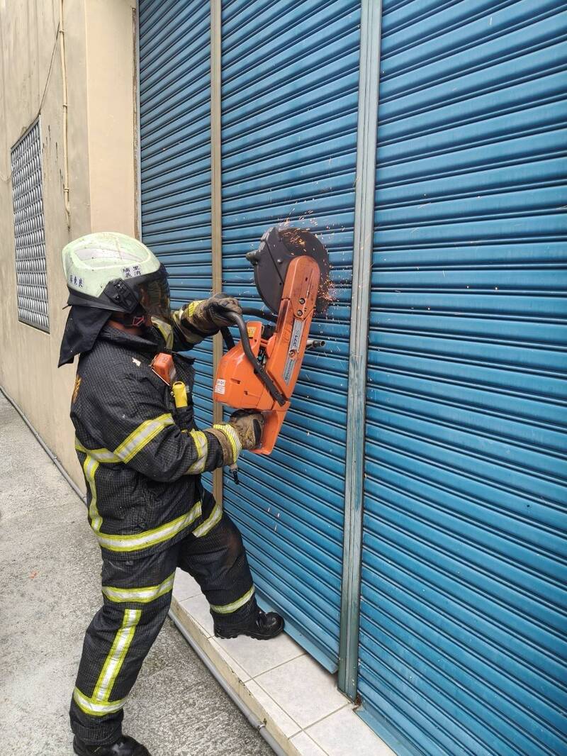 消防人员另外从后方切割铁卷门。(南投县消防局提供) 消防人员另外从后方切割铁卷门。(南投县消防局提供)